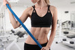 Sporty young woman usind elastic band during stretching workout at gym Sporty young woman usind elastic band during stretching workout at gym