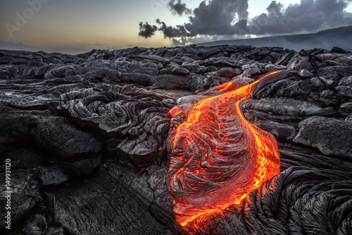 Plakat Red Orange vibrant Molten Lava flowing na szare lavafield i błyszczące skaliste grunty w pobliżu hawajski wulkan z vog na tle