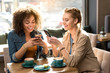 Laughing girls watching at cellphones Laughing girls watching at cellphones