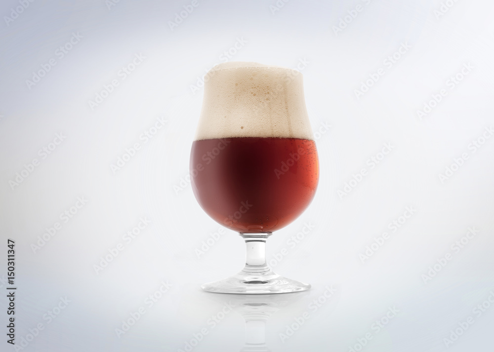 Glass of a belgian amber ale beer with foam. Isolated on white background.