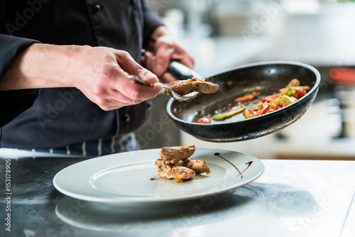 Fotoobraz na płótnie Szef kuchni wykończeniowe jedzenie na talerzu w restauracyjnej kuchni