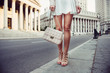 Closeup details of summer female casual street style outfit with luxury bag, skirt and high-heels. Fashionable girl standing at New York City street. Closeup details of summer female casual street style outfit with luxury bag, skirt and high-heels. Fashionable girl standing at New York City street.