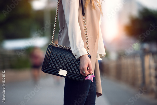 Plakat Zamyka up elegancka żeńska czarna rzemienna torba outdoors. Modna i luksusowa kobieca torba w stylu.