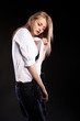 Gorgeous fashionable blonde model with suspenders and white shirt on black background in studio photo Gorgeous fashionable blonde model with suspenders and white shirt on black background in studio photo