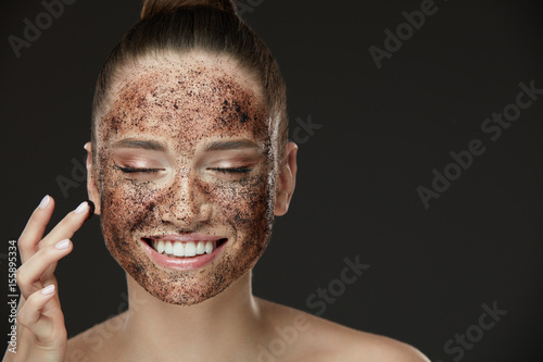 Plakat Peeling do twarzy. Uśmiechnięta dziewczyna stosowania Peeling Maska do kawy na skórze