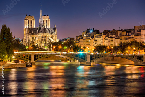  Notre Dame de Paris Cathedral, Seine River and the Sully Bridge at twilight. Summer evening on Ile Saint Louis, 4th Arrondissement in Paris. France