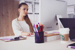 Young woman working in office, sitting at desk Young woman working in office, sitting at desk