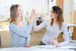Dressmakers giving eachother a high five Dressmakers giving eachother a high five