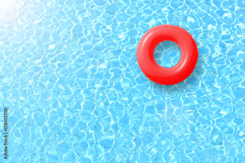 red swimming pool ring float in blue water and sun bright. concept color summer. red swimming pool ring float in blue water and sun bright. concept color summer.