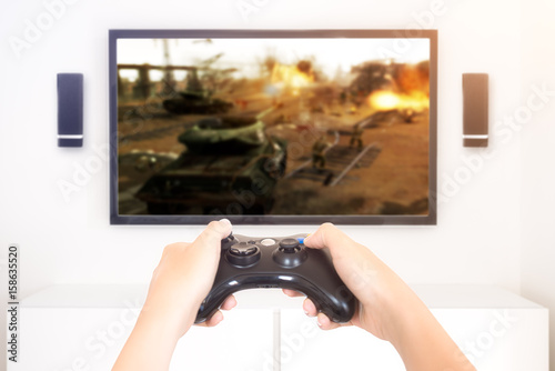Zdjęcie XXL Gracz grający konsoli wojennej gry wideo trzyma gamepad - wysoki kluczowy wizerunek