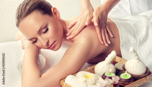Plakat Masaż i pielęgnacja ciała. Zabieg masażu ciała. Kobieta o masaż w salonie spa dla pięknej dziewczyny