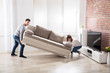 Couple Placing Sofa At Their New Home Couple Placing Sofa At Their New Home