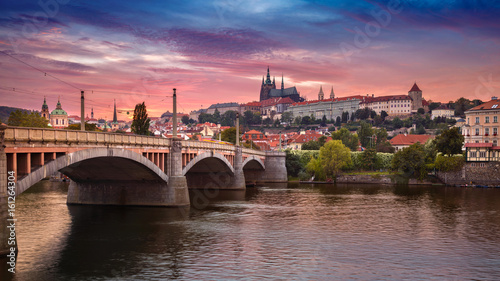 Plakat Praga o zachodzie słońca. Wizerunek Praga, stolica republika czech, podczas dramatycznego zmierzchu.