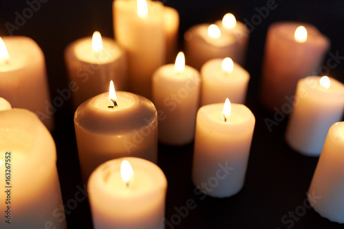 candles burning in darkness over black background