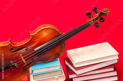 Fotoobraz na płótnie Muzyczny instrument stary skrzypce na książce i stosie książki