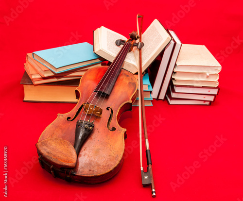 Fotoobraz na płótnie Muzyczny instrument stary skrzypce na książce i stosie książki