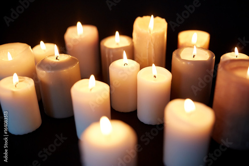 candles burning in darkness over black background