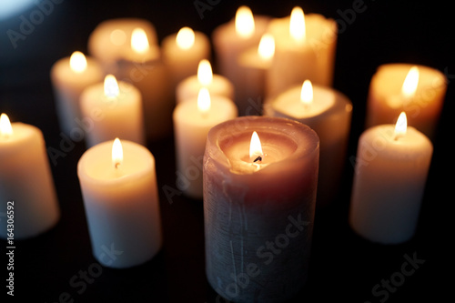 candles burning in darkness over black background