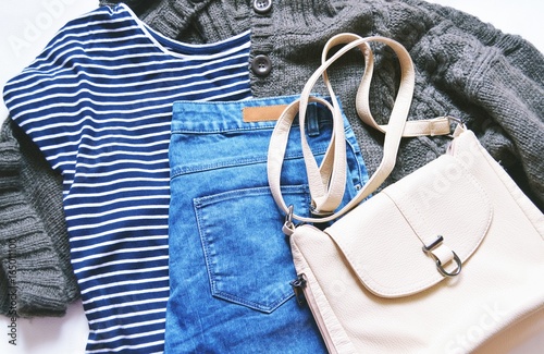 Zdjęcie XXL Płaskie świeckich moda odzież damska zdjęcie / Jesień i zima moda blogger strój. Koszula w paski, brązowy sweter z dzianiny wełnianej, niebieskie dżinsy z drelichowej i beżowej torby. Swobodny styl, modne zużycie