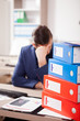 Corporate worker depressed from the workload at the office. His desk is full with a pile of folders and papers with finance charts are on the table. Corporate worker depressed from the workload at the office. His desk is full with a pile of folders and papers with finance charts are on the table.