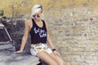 Young sexy blonde sitting on old jeep, grunge wall in background Young sexy blonde sitting on old jeep, grunge wall in background