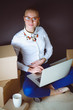 Woman sitting on the floor near a boxes with laptop . Businesswoman Woman sitting on the floor near a boxes with laptop . Businesswoman