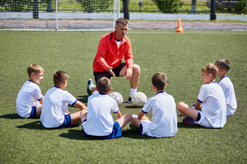 Coach Instructing Junior Football Team in Practice