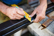 Man measuring off metal bar in workshop. Man measuring off metal bar in workshop.