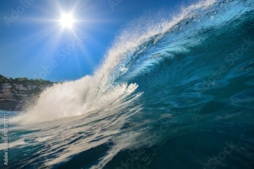Plakat Fala surfingu. Błękitny oceaniczny grzebień. Woda morska z słońcem nad niebieskim niebem na backround. Nikt na obrazie