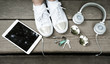 The concept of white color, headphones, tablet, glasses, sneakers and keys lie on a wooden surface. Office in the park The concept of white color, headphones, tablet, glasses, sneakers and keys lie on a wooden surface. Office in the park
