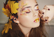 Beautiful young woman with autumn make up posing in studio over grey background. Fashion concept. Beautiful young woman with autumn make up posing in studio over grey background. Fashion concept.