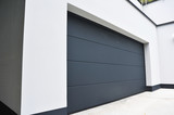 Moderne Einfahrt mit Beton-Wänden und Garage mit Automatik-Tor