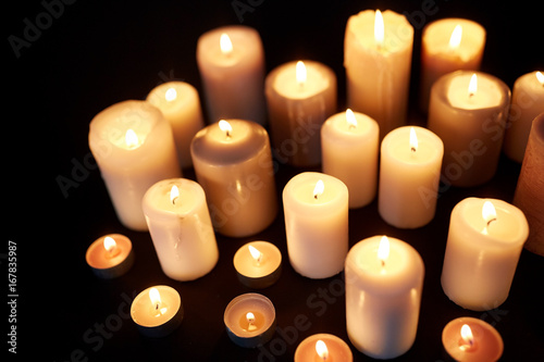 candles burning in darkness over black background