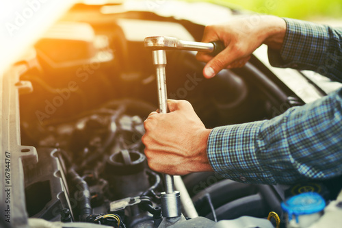 Zdjęcie XXL Auto mechanik pracuje z kluczem w silniku. Usługa naprawy samochodów