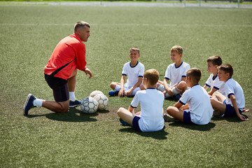 Coach Instructing Junior Football Team