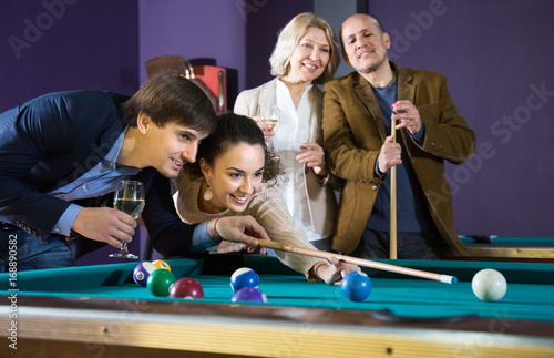 Fotoobraz na płótnie Pozytywna uśmiechnięta potomstwo para bawić się basenu w billiards