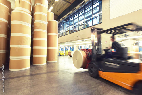 Zdjęcie XXL Wózek widłowy transportuje rolki papieru w magazynie - prędkość nagrywania ruchu // Wózek widłowy transportuje rolki papieru w magazynie w magazynie