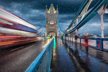 Auf der Tower Bridge in London im Herbst mit Schneeregen und vorbeifahrendem, roten Bus