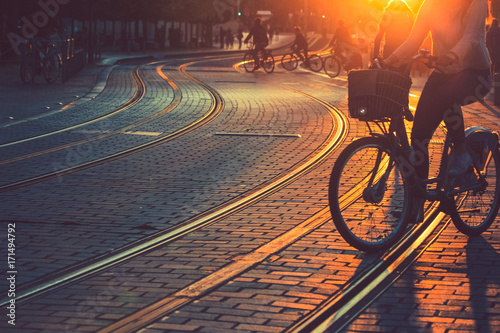 Zdjęcie XXL Zamazujący ludzie jedzie bicykl podczas zmierzchu w mieście Bordo w rocznika stylu i zbożowa tekstura z kopii przestrzenią