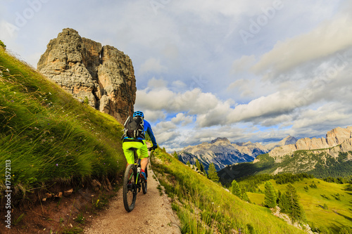 Plakat Turystyczne kolarstwo w Cortina d'Ampezzo, oszałamiające góry skaliste w tle. Mężczyzna jedzie MTB enduro przepływu ślad. Prowincja Tyrolu Południowego we Włoszech, Dolomity.