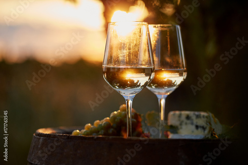 Two glasses of white wine with food at sunset