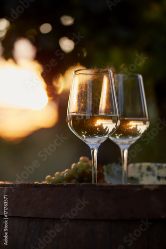Two glasses of white wine with food at sunset