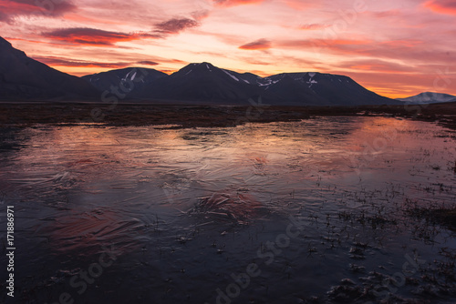 Landscape travel of a nature of a sunset sunrise with clouds in the mountains of Spitsbergen Svalbard near the Norwegian city Longyearbyen