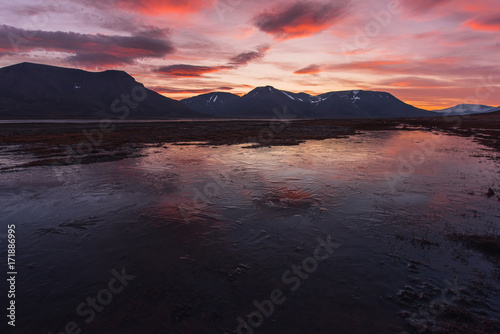 Landscape travel of a nature of a sunset sunrise with clouds in the mountains of Spitsbergen Svalbard near the Norwegian city Longyearbyen
