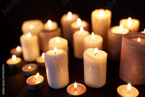 candles burning in darkness over black background