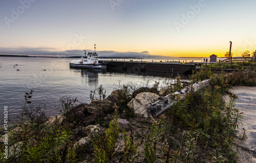 Zdjęcie XXL Sunrise Lake Superior. Mały holownik cumował na Jeziornym Wyższym doku z nabrzeżnym wschodem słońca w tle. Narodowy teren rekreacyjny Grand Island. Munising, Michigan.