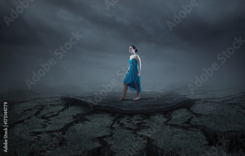 A woman stands on a solid rock