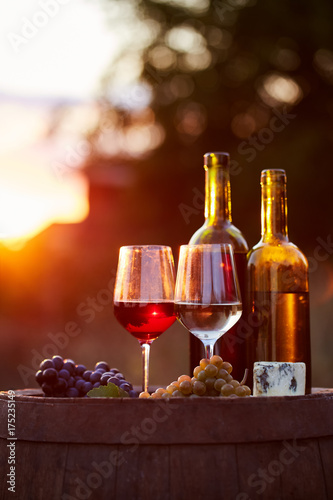Two glasses of white and red wine with food at sunset
