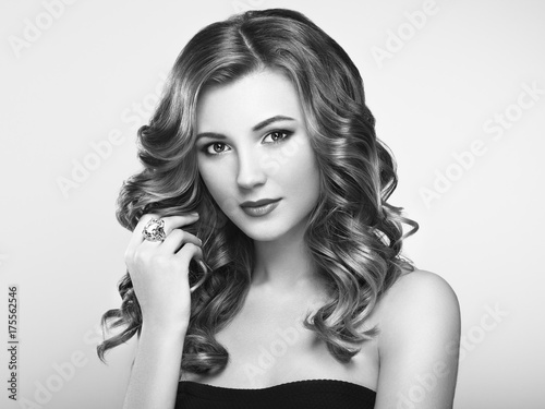 Plakat Blond kobieta z długimi i objętościowo lśniącymi falującymi włosami. Piękny model z kręcone fryzury. Idealny makijaż. Model w stylu piękności