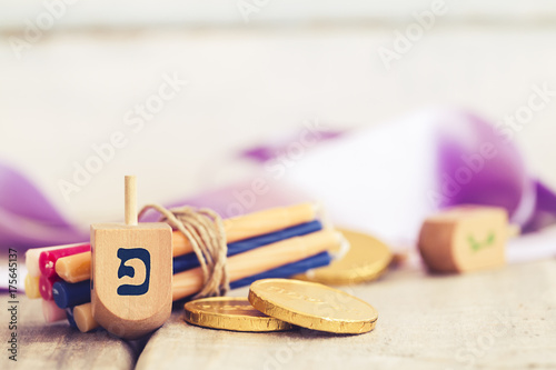 Zdjęcie XXL Chanuka dreidels z niektóre Hanukkah świeczkami i Hanukkah monetami na rocznika drewnianym tle z kopii przestrzenią.